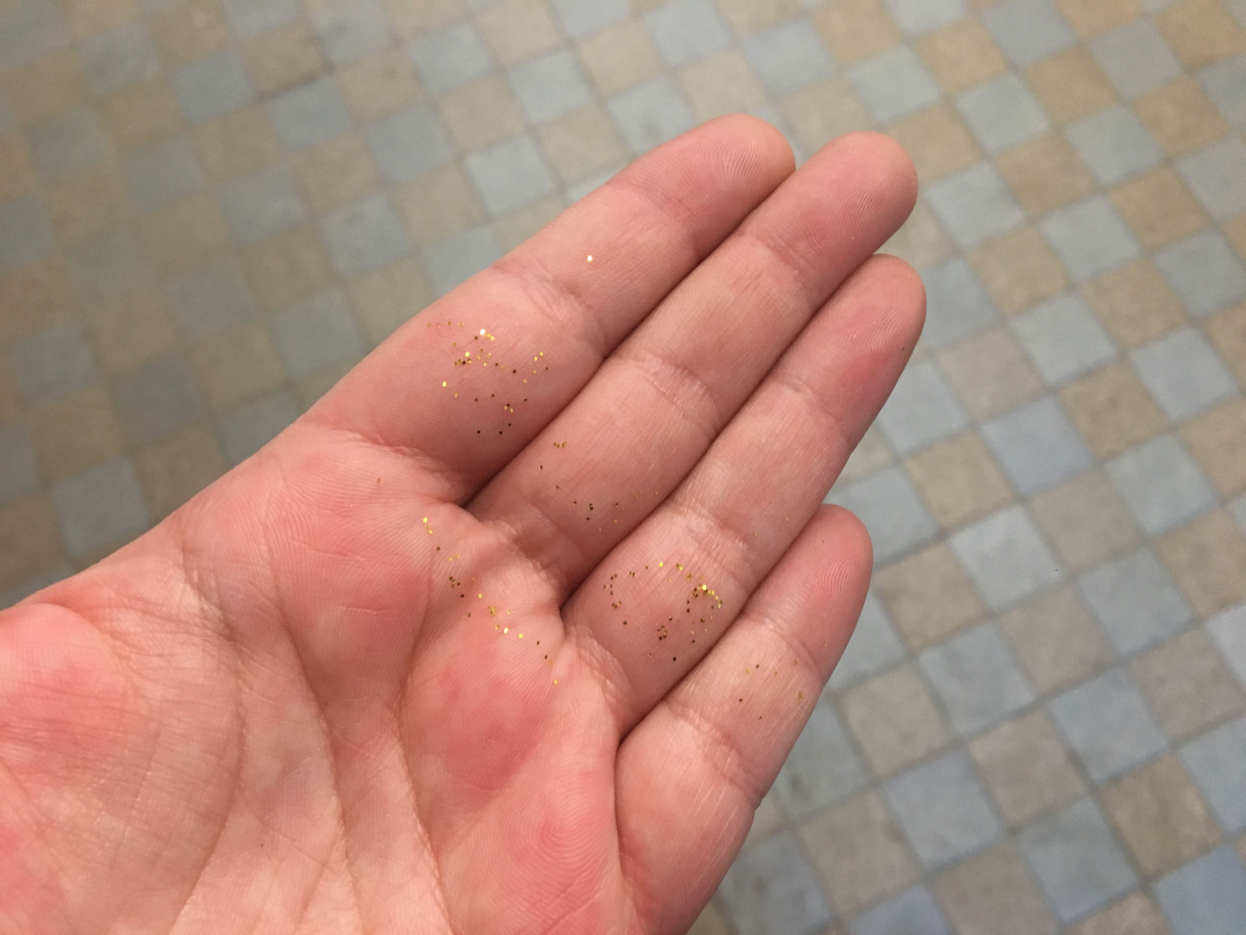 Une main est recouverte de paillettes. Elle a dû ouvrir la porte.